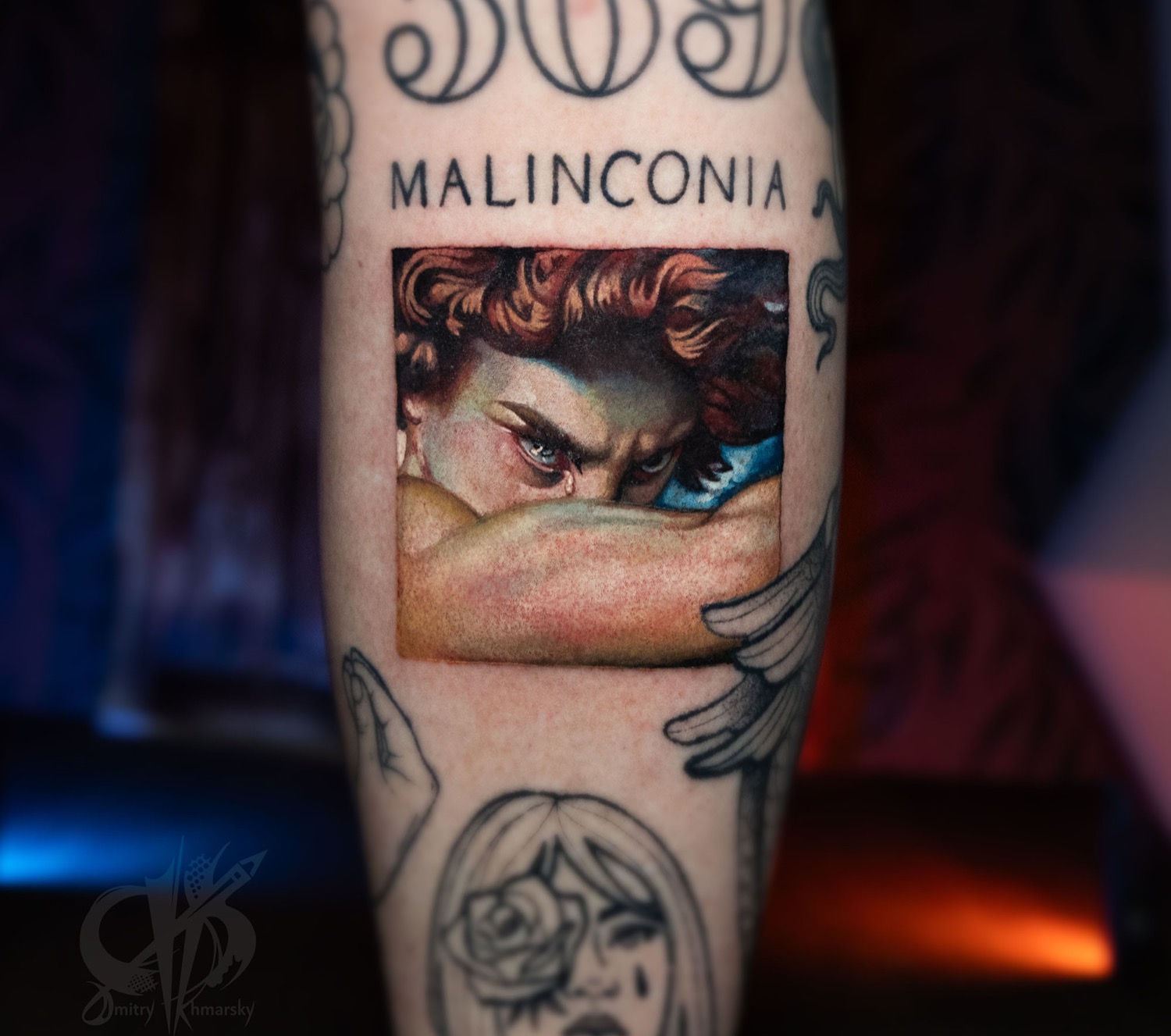 Color tattoo detail with painted eyes and lettering